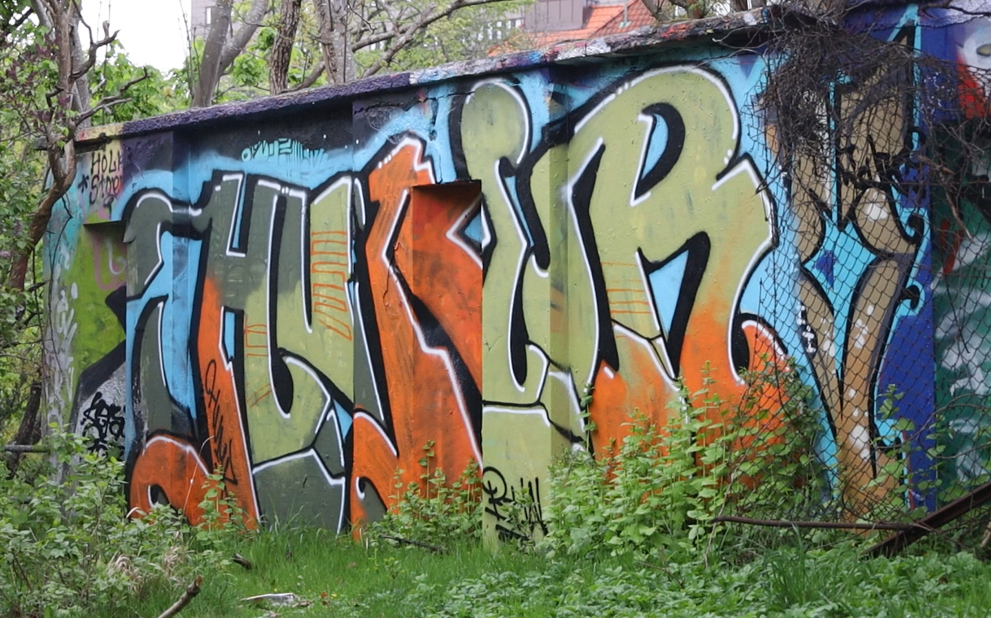 Bild på en piece, det vill säga en större graffitimålning med blockiga, dansande bokstäver.